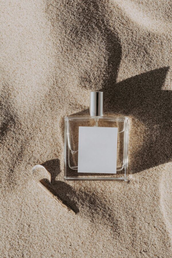 close up shot of a perfume bottle on the sand